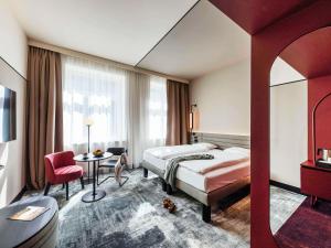 ミュンスターにあるNovotel Münster Cityのベッドとテーブルが備わるホテルルームです。