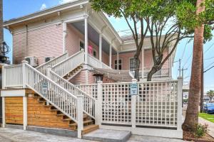 een roze huis met een wit hek ervoor bij Sugar's INN Room #2 in Galveston