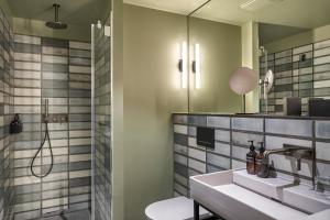 a bathroom with a sink and a shower at Gekko House Frankfurt, a Tribute Portfolio Hotel in Frankfurt/Main