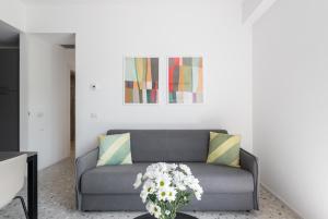 uma sala de estar com um sofá com flores numa mesa em Numa I Verso Apartments em Roma