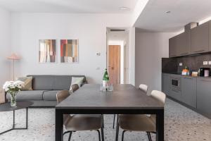 uma cozinha e sala de estar com uma mesa e um sofá em Numa I Verso Apartments em Roma