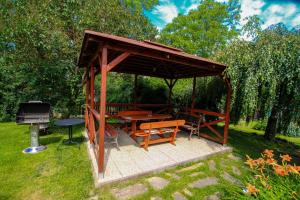 einen Pavillon mit einem Picknicktisch und einem Grill in der Unterkunft Penzion Na Vyhlídce in Lukov