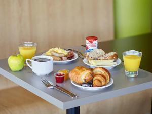 a tray with breakfast foods and drinks on a table at B&B HOTEL Paris Roissy CDG Aéroport in Roissy-en-France