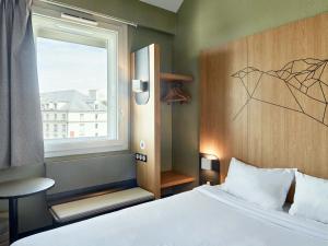 a small bedroom with a bed and a window at B&B HOTEL Paris Roissy CDG Aéroport in Roissy-en-France