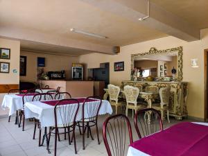 een eetkamer met tafels en stoelen en een spiegel bij Pension Casa Samurai in Braşov