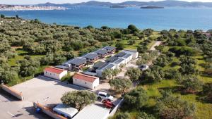 uma vista aérea de um celeiro com a água ao fundo em Mobile homes Kamp Maslina, Biograd na Moru em Biograd na Moru