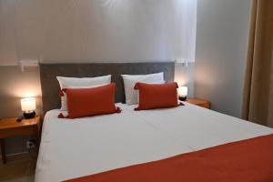 sypialnia z łóżkiem z 2 czerwonymi poduszkami w obiekcie H49 Apartman Wellness & Spa - Adults only w mieście Sovata