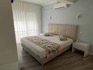 um quarto com uma cama grande e 2 almofadas em Hotel Ancora Mar na Nazaré