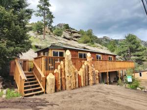 une maison en rondins avec une clôture en rondins dans l'établissement Pine Haven Resort, à Estes Park