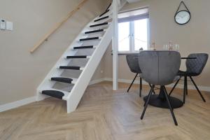 - un escalier dans le salon avec une table et des chaises dans l'établissement appartement-gratis parkeren -bij strand en in het centrum, à Noordwijk