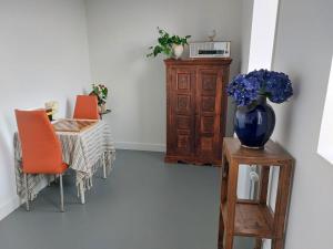 uma sala de jantar com uma mesa e um vaso de flores azuis em Medina B&B hartje Arnhem em Arnhem