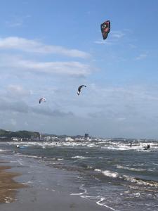 three kites flying in the sky over the ocean at apartamente Melodi in Durrës