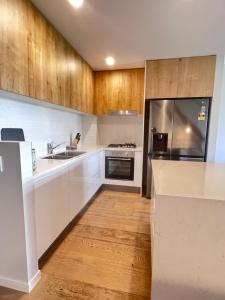 a kitchen with white counters and wooden cabinets at Near New 4br townhouse next to shopping mall in Gold Coast