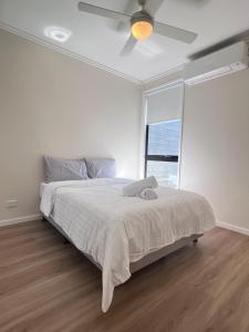 a bedroom with a bed with a ceiling fan at Near New 4br townhouse next to shopping mall in Gold Coast