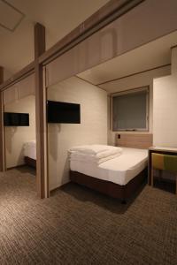 מיטה או מיטות בחדר ב-Cabin & Capsule Hotel J-SHIP Osaka Namba