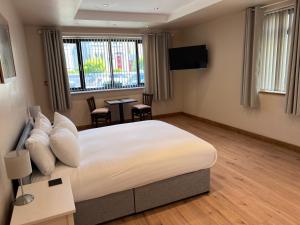 a hotel room with a bed and a table and chairs at Feeney's Audubon Lodge in Galway