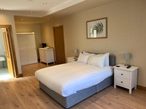 a bedroom with a large white bed with two night stands at Feeney's Audubon Lodge in Galway