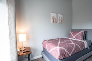 1 dormitorio con 1 cama y 1 mesa con lámpara en Girlfriend Getaway Suite, en Nashville