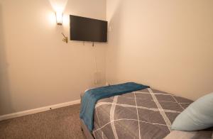 1 dormitorio con 1 cama y TV de pantalla plana en la pared en Girlfriend Getaway Suite, en Nashville