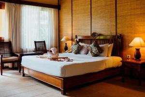 een slaapkamer met een bed met een teddybeer erop bij Sri Phala Resort & Villa in Sanur