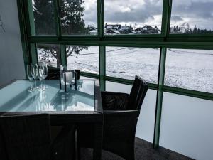 een tafel met wijnglazen en uitzicht op de sneeuw bij Apartment Flieder - F 96 by Interhome in Dittishausen