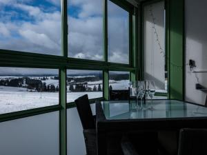 een eetkamer met een tafel en uitzicht op de sneeuw bij Apartment Flieder - F 96 by Interhome in Dittishausen