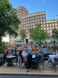 a group of people sitting at tables in a park at Hostel The Golden Stork in The Hague