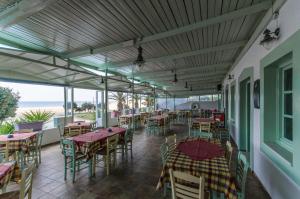 - un restaurant avec des tables et des chaises donnant sur l'océan en arrière-plan dans l'établissement Psili Ammos Studios, à Plage d'Aliko