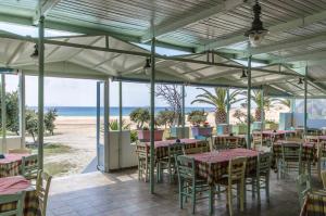 - un restaurant avec des tables et des chaises sur la plage dans l'établissement Psili Ammos Studios, à Plage d'Aliko