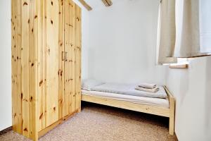 a bed in a room with a wooden wall at Pension Barborka in Boží Dar