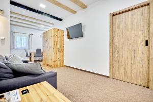 a living room with a couch and a sliding door at Pension Barborka in Boží Dar