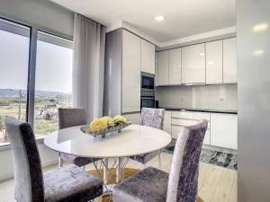 a kitchen with a white table and chairs and a window at Rancho Tá-Mar Apartment Nazaré Beach in Nazaré