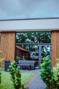 Ein Gebäude mit einer Terrasse mit Sofas und Fenstern in der Unterkunft Cozy 4 You in Klaipėda