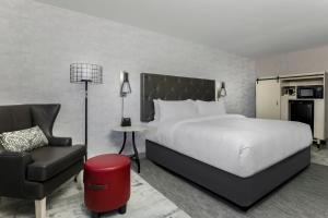 um quarto de hotel com uma cama e uma cadeira em Four Points by Sheraton Amarillo Central em Amarillo