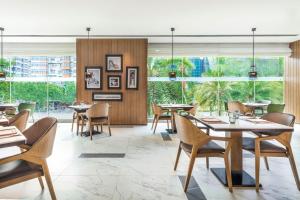 - un restaurant avec des tables, des chaises et de grandes fenêtres dans l'établissement Sheraton Guangzhou Hotel, à Canton