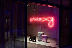 un panneau de néon dans une fenêtre de rangement avec bagages dans l'établissement Moxy Brussels City Center, à Bruxelles