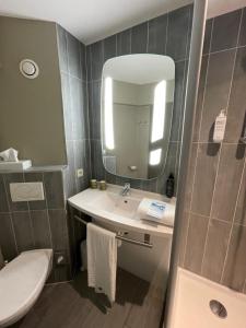 a bathroom with a sink and a toilet and a mirror at ibis Gent Centrum St. Baafs Kathedraal in Ghent