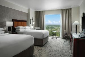 a hotel room with two beds and a large window at Sheraton Myrtle Beach in Myrtle Beach