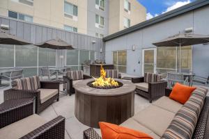 un patio con braciere, sedie e un edificio di TownePlace Suites by Marriott Indianapolis Airport a Indianapolis