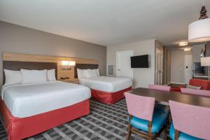 una camera d'albergo con due letti e un tavolo di TownePlace Suites by Marriott Indianapolis Airport a Indianapolis