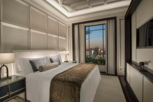 - une chambre avec un grand lit et une grande fenêtre dans l'établissement The St. Regis Astana, à Astana