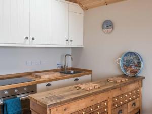 uma cozinha com armários brancos e um balcão de madeira em Little Tern, Beachside chalet 6, access to beach em Cowes