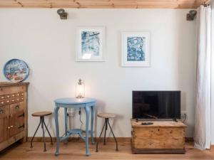 uma sala de estar com uma mesa azul e uma televisão em Little Tern, Beachside chalet 6, access to beach em Cowes