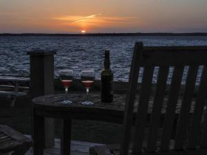 uma mesa com dois copos de vinho e uma garrafa em Little Tern, Beachside chalet 6, access to beach em Cowes