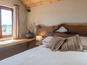 um quarto com uma cama com uma cabeceira em madeira e uma janela em Little Tern, Beachside chalet 6, access to beach em Cowes