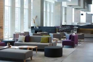 een grote lobby met banken, tafels en ramen bij Courtyard by Marriott Santiago Las Condes in Santiago