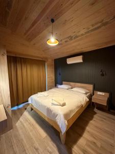 een slaapkamer met een groot bed en een houten plafond bij Cirali Hotel in Cıralı