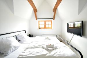 a bedroom with a white bed and a tv at Black Billard l Loft für 2-4 Personen l Wohlfühlen in Altstadtnähe in Landshut