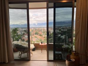 Zimmer mit Glastüren und Stadtblick in der Unterkunft Depto a estrenar increíble vista 180º Cocha in Cochabamba