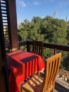 une table et des chaises sur une terrasse couverte avec un tissu de table rouge dans l'établissement Tongoy Beach Tinyhouse, à Tongoy